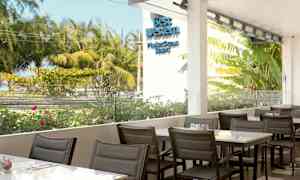 Uteservering med utsikt över grönskande träd och blommor. (AI-genererad text)