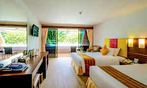 Hotellrum med två sängar, sittgrupp och balkong. (AI-genererad text)