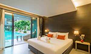 Ett hotellrum med en stor säng, bredvid ett nattduksbord med dekor och en glidande glasdörr som leder ut till en pool. (AI-genererad text)