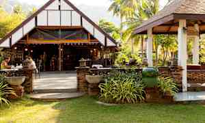 En öppen restaurang med traditionell byggnad i grön omgivning. (AI-genererad text)