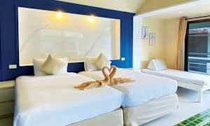 Bild av ett hotellrum med två enkelsängar, en dekorativ tvålhjärta och en dagbädd vid sidan. (AI-genererad text)