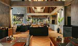 Interiörbild av en restaurang med rustik inredning, träbord och en bufféstation i mitten. (AI-genererad text)