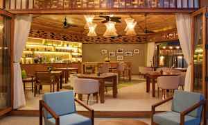 Interiör av en mysig restaurang med träinredning, bord och stolar samt dekorativa lampor. (AI-genererad text)