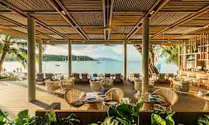 En strandnära restaurang med sittplatser och utsikt över havet. (AI-genererad text)