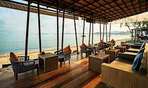 Uteservering med sittplatser vid havet. (AI-genererad text)