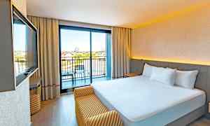 Hotellrum med en dubbelsäng och balkong. (AI-genererad text)