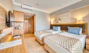 Hotellrum med två enkelsängar, en skrivbord och en dörr till badrummet. (AI-genererad text)