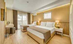 Ett hotellrum med två sängar, modern inredning och en balkong. (AI-genererad text)