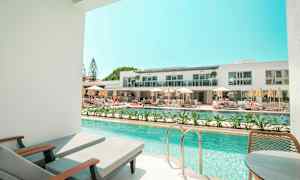 Privat poolområde med utsikt över ett modernt hotellkomplex. (AI-genererad text)