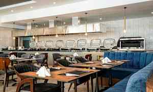 Restaurang med dukade bord och en buffédisk i bakgrunden. (AI-genererad text)