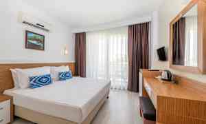 Ett hotellrum med en dubbelsäng, skrivbord och balkong. (AI-genererad text)