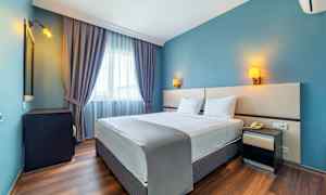 Dubbelrum med blå väggar och fönster med gardiner. (AI-genererad text)