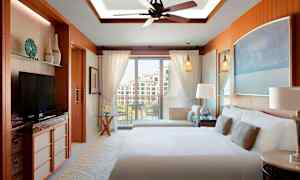 Hotellrum med dubbelsäng, balkong och modern inredning. (AI-genererad text)