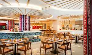 Interiör av en färgglad och stilfull restaurang med träbord och stolar. (AI-genererad text)