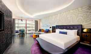 Modernt inrett hotellrum med stor säng och sittgrupp. (AI-genererad text)