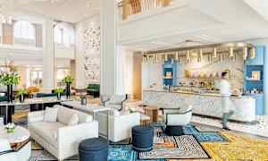 Ett elegant hotellobby med moderna möbler och en marmordisk. (AI-genererad text)