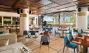 En modern restaurang med trädetaljer och utsikt mot utomhusområdet. (AI-genererad text)