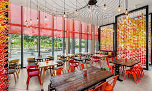 Ett café med färgglada möbler och väggar med dekorativa detaljer. (AI-genererad text)