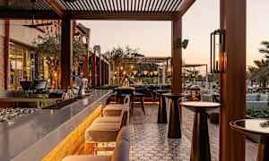 Utomhusbar med sittplatser och bord i kvällsljus. (AI-genererad text)