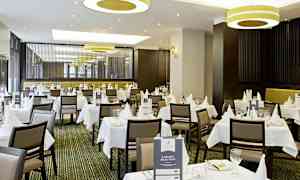 En elegant restaurang med vita dukar och dukning. (AI-genererad text)