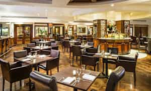 En elegant restaurang med bord och stolar, dukade för måltider. (AI-genererad text)