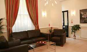 Ett rum med soffor, soffbord, gardiner och dekorationer. (AI-genererad text)