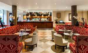 Restaurang med röda bänkar och glasbord. (AI-genererad text)