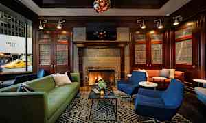 Ett elegant vardagsrum eller loungeområde med sittplatser i form av soffor och stolar, en öppen spis och dekorativa träpaneler. (AI-genererad text)