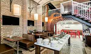 En restauranglokal med sittplatser, bord och en bufféservering. (AI-genererad text)