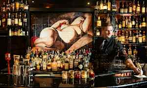 En bar fylld med flaskor av sprit och tillbehör, med en målning av en figur i bakgrunden. (AI-genererad text)