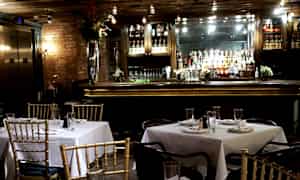 En restaurang med dukade bord och en bardisk i bakgrunden. (AI-genererad text)