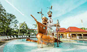 En lekplats med ett skeppstema i en pool, vatten rinner från olika delar av skeppet. (AI-genererad text)