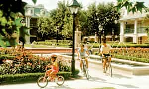 Personer cyklar längs en stig bredvid en vacker fontän i en park. (AI-genererad text)