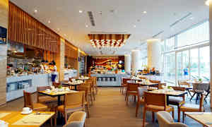 En rymlig restaurang med bord och stolar, en bufféstation och modern belysning. (AI-genererad text)