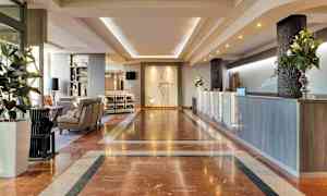 Hotelllobb med marmorgolv, reception och sittgrupp. (AI-genererad text)