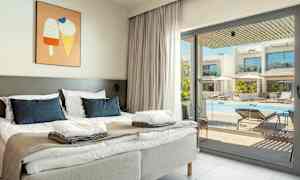 Sovrum med dubbelsäng och fönster mot en pool. (AI-genererad text)