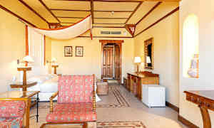 Ett hotellrum med säng, trädetaljer och sittgrupp. (AI-genererad text)