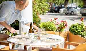 En dukad utomhusbordsinställning med matplats och dekorationer. (AI-genererad text)