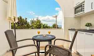 Balkong med bord, stolar och utsikt. (AI-genererad text)