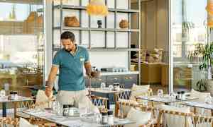 Ett caféområde med bord, stolar och ett öppet serveringsutrymme. (AI-genererad text)