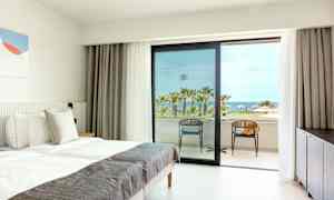 Hotellrum med bäddad säng och utsikt över palmträd och hav. (AI-genererad text)