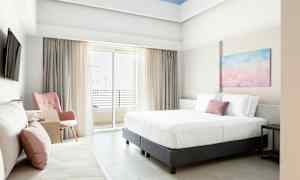 Bild av ett ljust hotellrum med en stor säng, stol och balkong. (AI-genererad text)