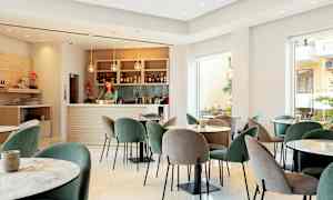 En modern lounge med bord och stolar samt en välutrustad bar. (AI-genererad text)