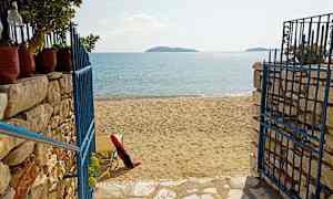 En strand med sand och en blå metallgrind. (AI-genererad text)