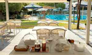 En utomhusmiljö med bord och stolar, där poolområdet syns i bakgrunden. (AI-genererad text)