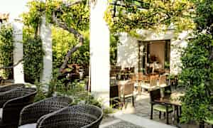 En grönskande uteservering med trädgårdsmöbler och soligt väder. (AI-genererad text)