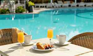 Ett bord med frukostmat vid en pool. (AI-genererad text)