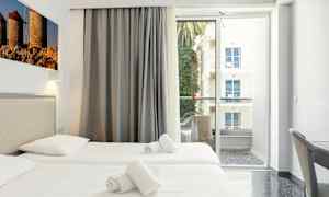 Hotellrum med två enkelsängar, balkong med utsikt. (AI-genererad text)