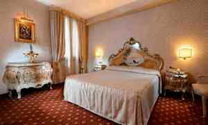 Ett elegant inrett sovrum med en stor säng, matchande sängbord och dekorativa möbler. (AI-genererad text)