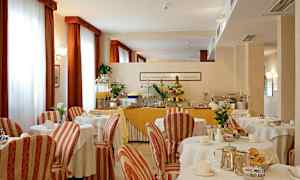 Ett matrum inredd med dukade bord och en buffé med frukt och juice. (AI-genererad text)